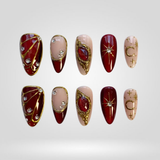 Red Royale press-on nails — gold starburst on deep red