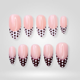 Dot Play press-on nails with black and white polka-dot French tips on almond shape