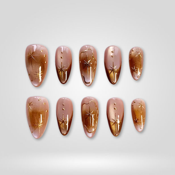 Bronze Stars press-on nails — golden star accents with shimmer on almond