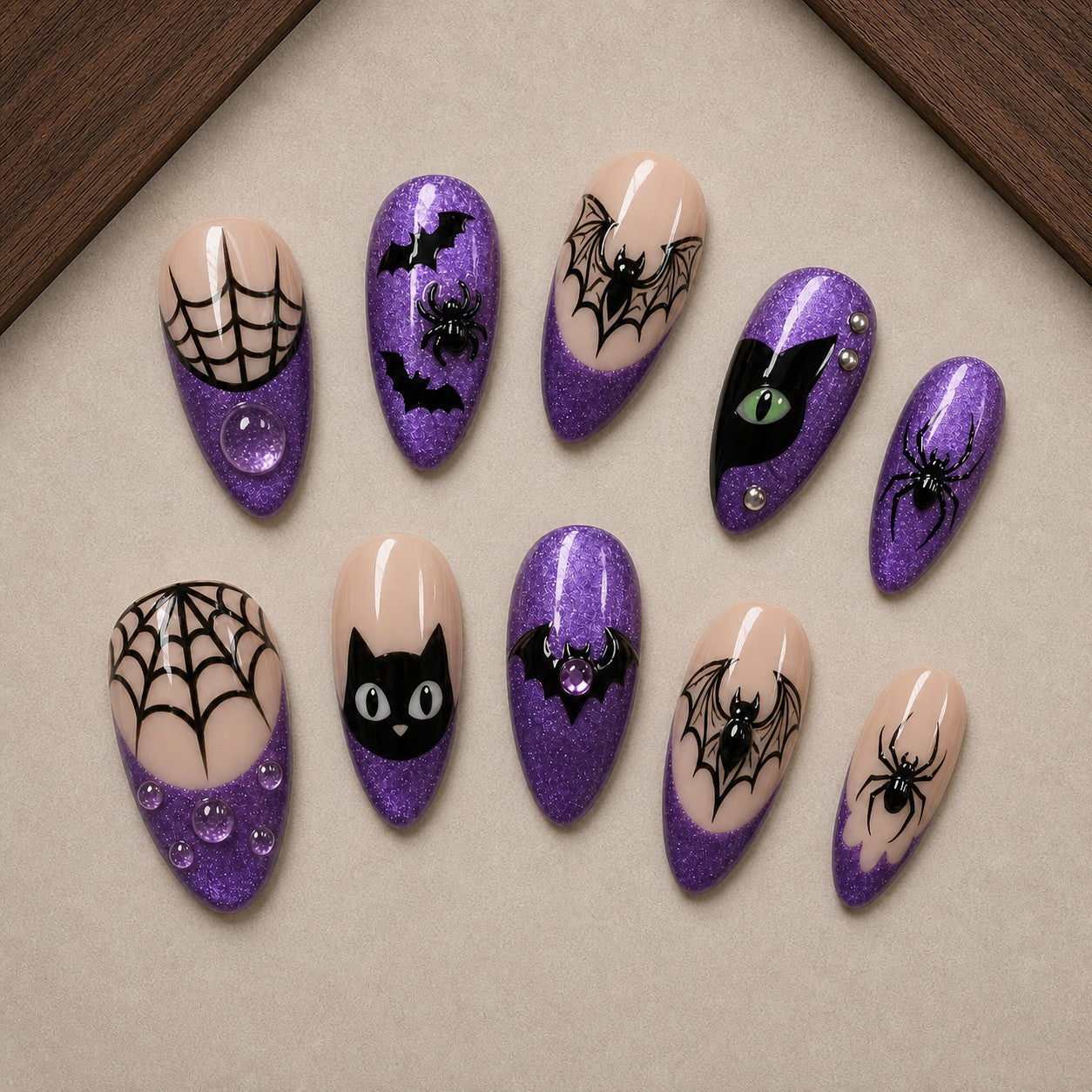 Amethyst Web Halloween press-on nail set displayed in a walnut tray — almond shape