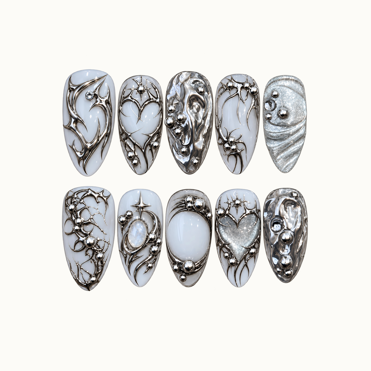 Ten milky white and silver nails arranged in two rows on a light background, featuring chrome swirls, starbursts, hearts, and bead-like accents.