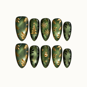 Ten glossy green nails arranged in two rows on a light neutral background, with gold-colored Christmas motifs, leafy branches, and dark foliage.