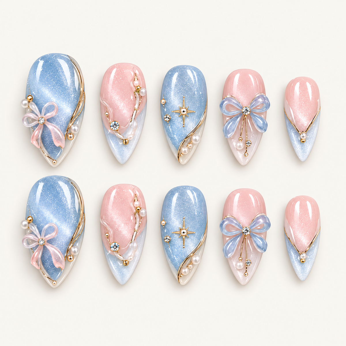 Ten pink and icy blue shimmering nails arranged in two rows on a light neutral background, decorated with raised bows, gold-tone starbursts, and pearl-like beads.
