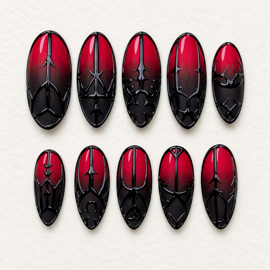 Ten glossy crimson-to-black ombré press-on nails with raised-looking gothic gate, arch, and floral-inspired black linework on a light neutral background.