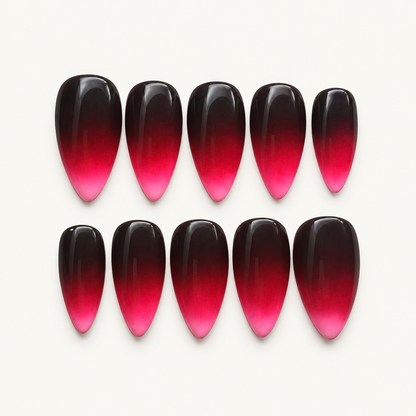 Glossy black-plum to fuchsia-pink ombré press-on nails displayed as a coordinated set.