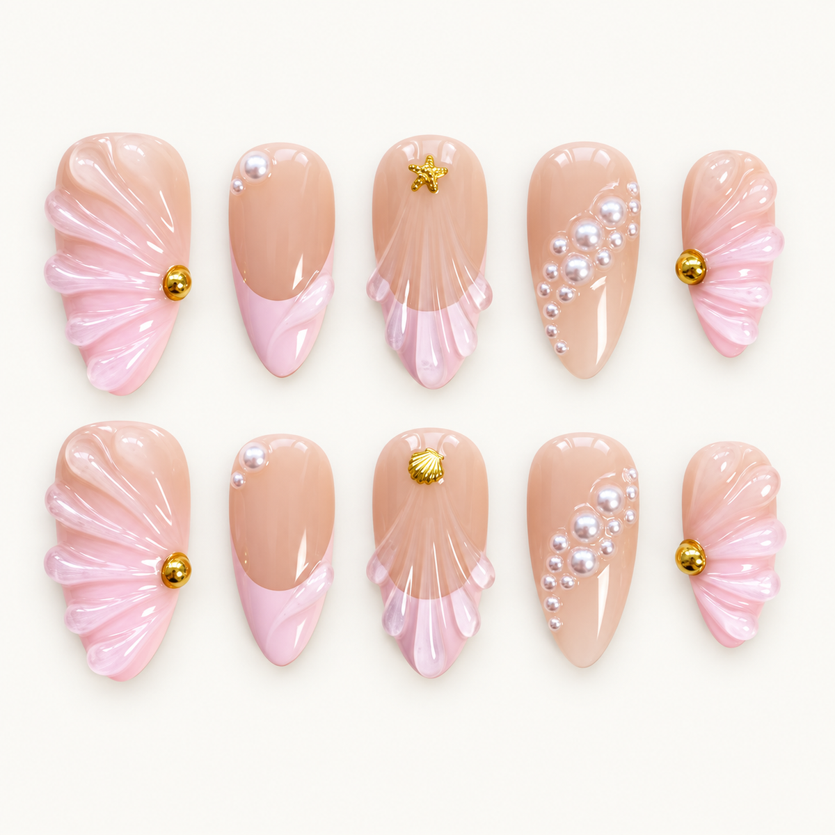 Ten glossy nude blush nails in two rows on a light background, with raised pink shell fans, pearl-like accents, and gold-tone sea motifs.