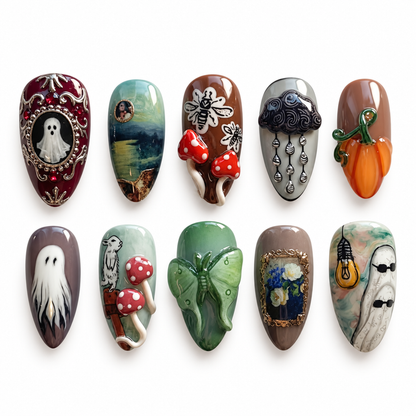 Ten coordinated Mosslight Manor nails arranged on a light textured surface, showing ghost, mushroom, botanical, lantern, and raised autumn motifs.
