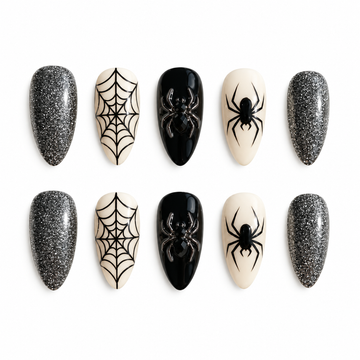 Ten coordinated press-on nails in silver glitter, glossy black, and ivory with black spiderweb and spider accents arranged in two rows.
