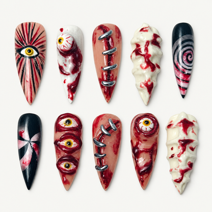 Ten pointed press-on nails arranged on a pale background with bloodshot eyes, red splatter, stitches, spirals, bows, and black accents.