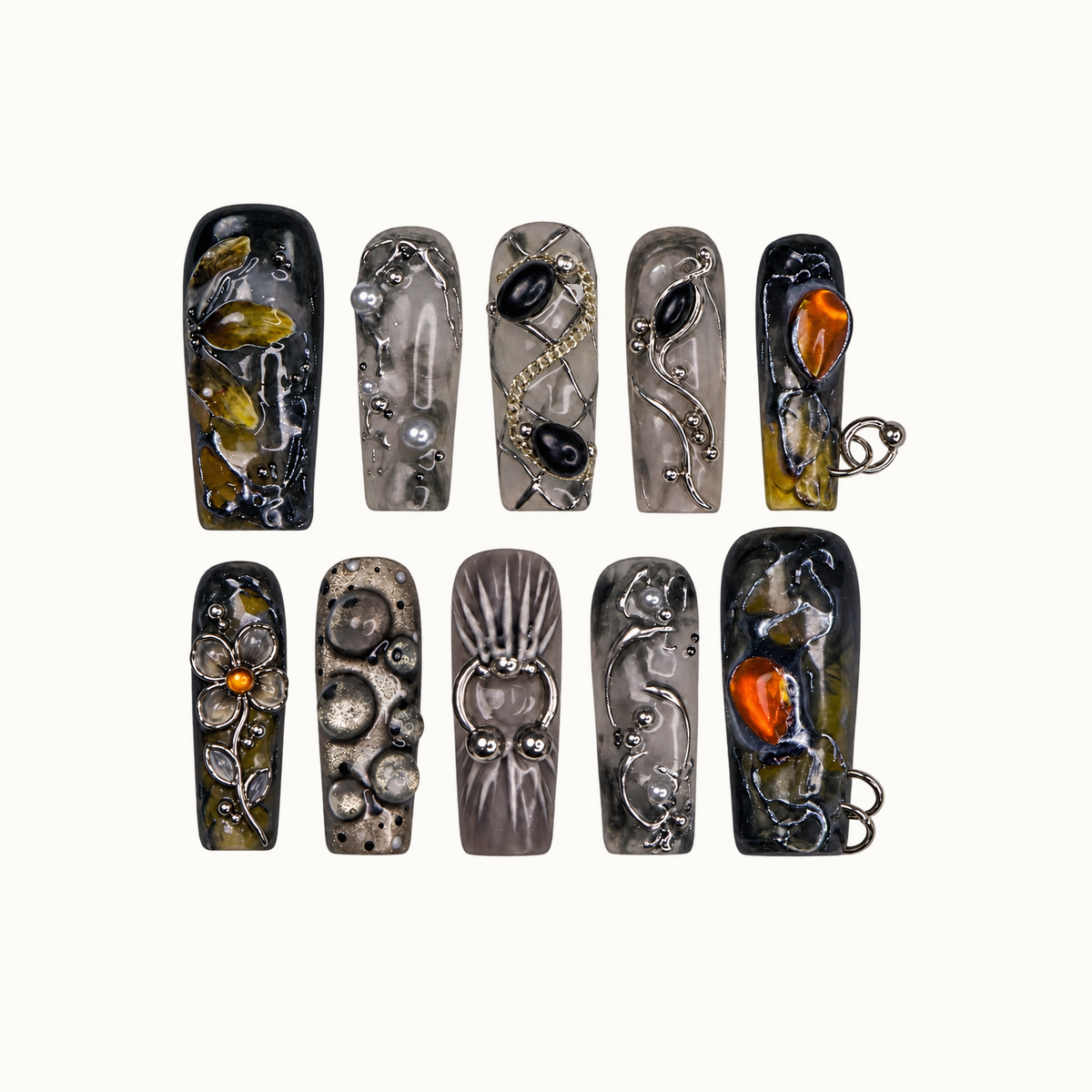 Ten coordinated nails in two rows on a light background, featuring smoky gray, charcoal, olive, amber-orange accents, floral detail, and metallic-looking scrollwork.