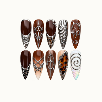 Ten pointed nails arranged in two rows on a pale background, featuring cocoa brown, silver-toned spirals and stars, tortoiseshell-style accents, and pearly white.