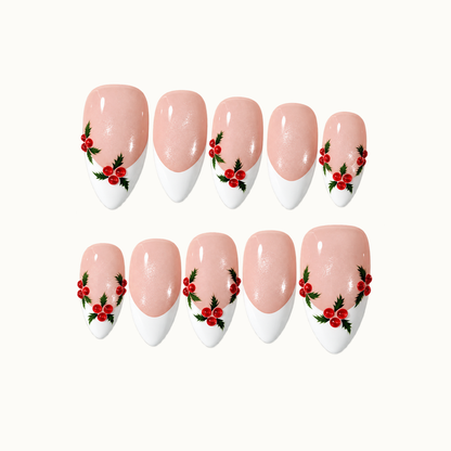 Ten blush pink shimmer nails arranged in two rows on a light neutral background, with white French tips and red holly berry accents with green leaves.