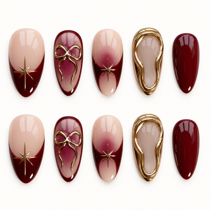 Ten burgundy and blush nude nails arranged in two rows on a light background, featuring gold bows, starbursts, and layered gold borders.