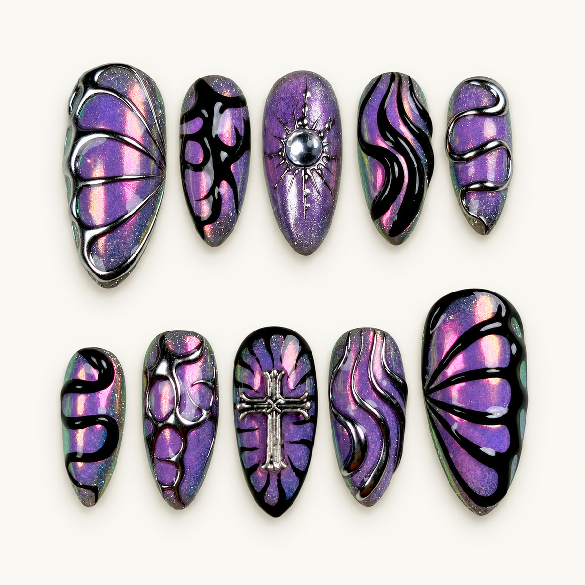 Ten coordinated purple mirror-shimmer press-on nails with black abstract swirls, silver-toned raised accents, cross detail, and pink-green flashes.