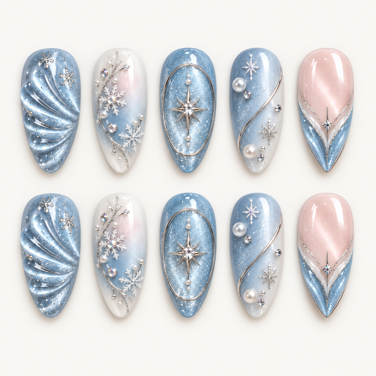 Ten glossy nails arranged in two rows on a light neutral background, featuring icy blue, white, and blush pink with snowflakes, starbursts, and pearl-like accents.