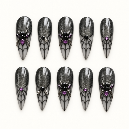 Midnight Web press-on nail set with black shimmer, smoky gray spiderweb tips, purple gems, and dimensional spider accents.