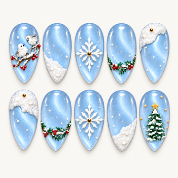 Ten icy blue winter press-on nails arranged in two rows, featuring birds, snowflakes, snowy drifts, evergreen berries, and a decorated tree.