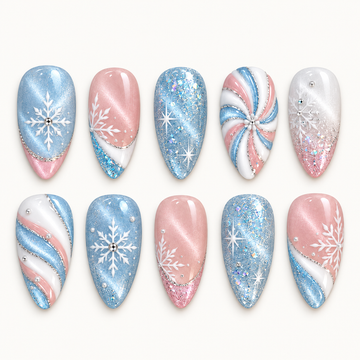 Ten pastel blue, pink, and white nails arranged in two rows on a light background, featuring snowflakes, starbursts, glitter, and swirls.