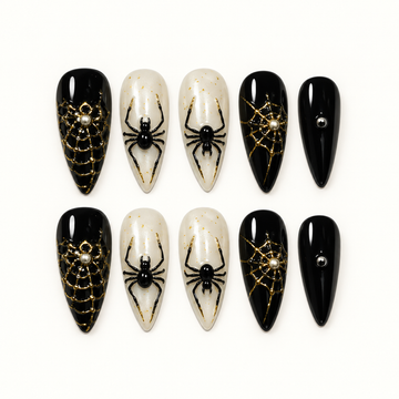 Midnight Web press-on nail set with glossy black, pearly ivory, metallic gold web details, and raised black spider accents