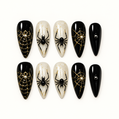 Midnight Web press-on nail set with glossy black, pearly ivory, metallic gold web details, and raised black spider accents