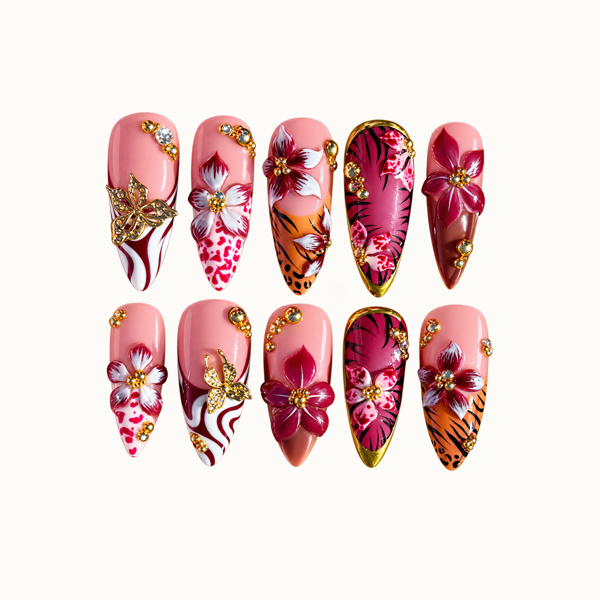 Ten coordinated nails in two rows on a light background, featuring pink and burgundy flowers, animal-print accents, gold-tone butterflies, and gems.