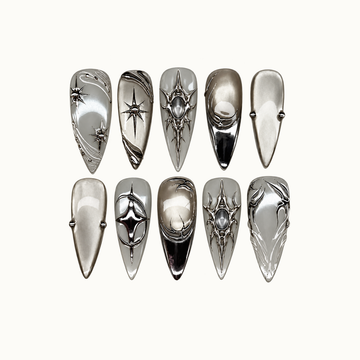 Ten pointed silver and gray nails in two rows on a light background, featuring chrome starbursts, curved lines, and smoky oval accents.