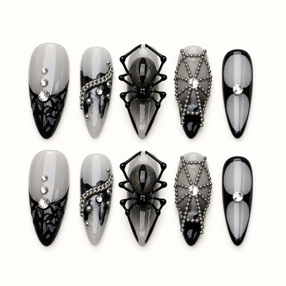 Midnight Web press-on nails in smoky gray and glossy black with dimensional spider, web, bead-chain, and crystal-inspired accents.
