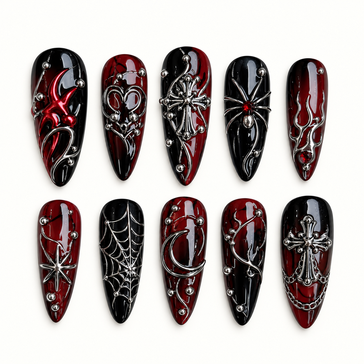 Ten coordinated glossy black and deep red press-on nails with raised silver-toned spiderweb, spider, cross, crescent, and starburst details on a light neutral background.