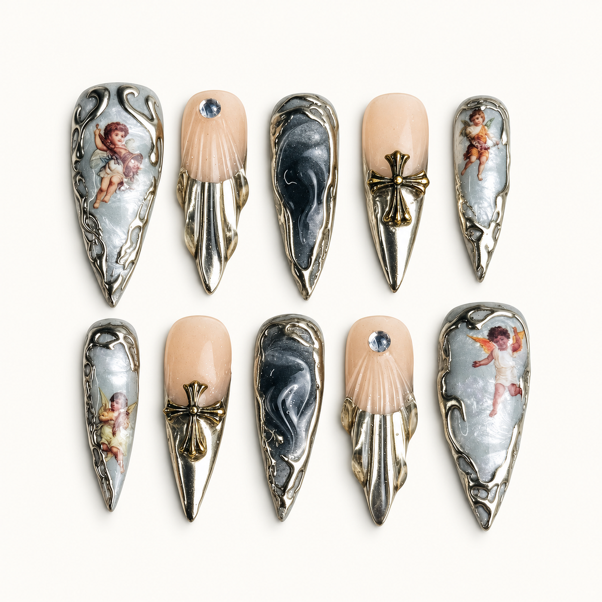 Ten coordinated pointed press-on nails with reflective silver sculpted frames, nude accents, winged-figure artwork, bows, and crystals on a light background.
