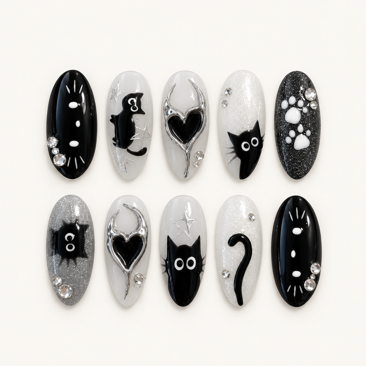 Chrome Void Cats press-on nail set arranged in two rows, showing black cat figures, silver-edged black hearts, paw prints, glitter, and clear rhinestones.