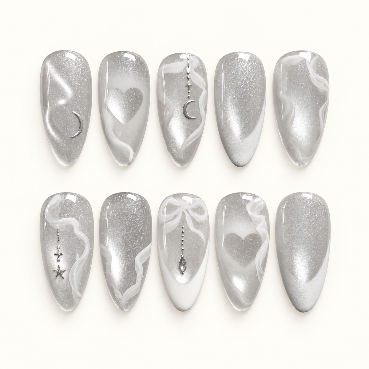 Ten silver shimmer nails in two rows on a pale background, with white swirls, hearts, crescent moons, stars, and a bow accent.