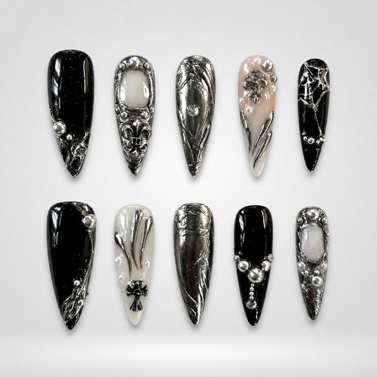 Chrome Relic gothic press-on nails — black, ivory, blush, and silver with ornate crosses on stiletto