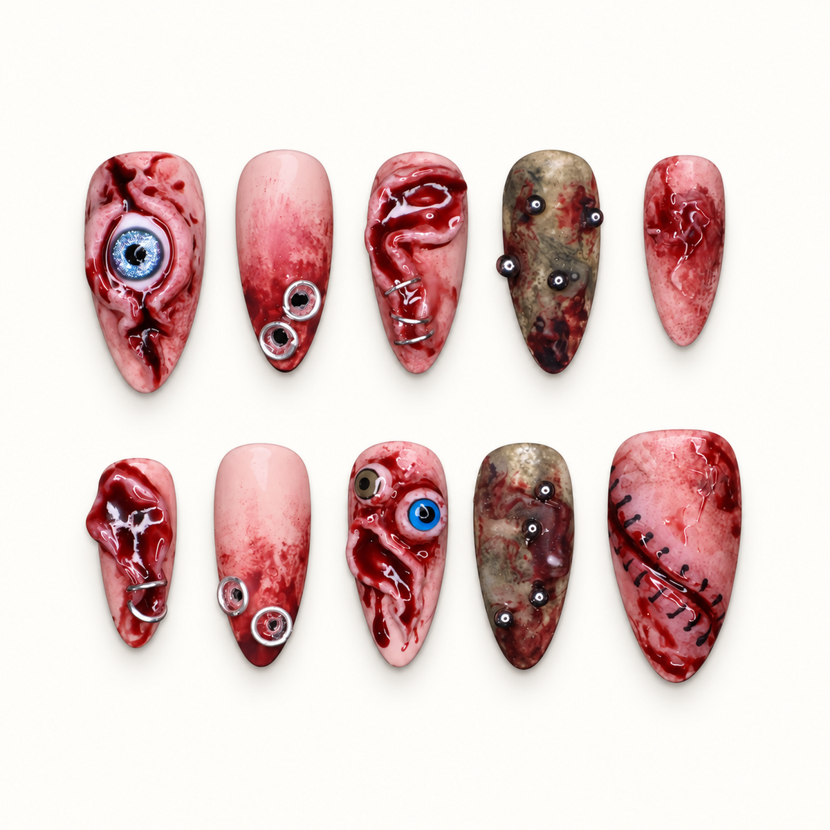 Ten horror-inspired press-on nails on a dark background with crimson marbling, eye motifs, stitched details, and silver-tone accents.