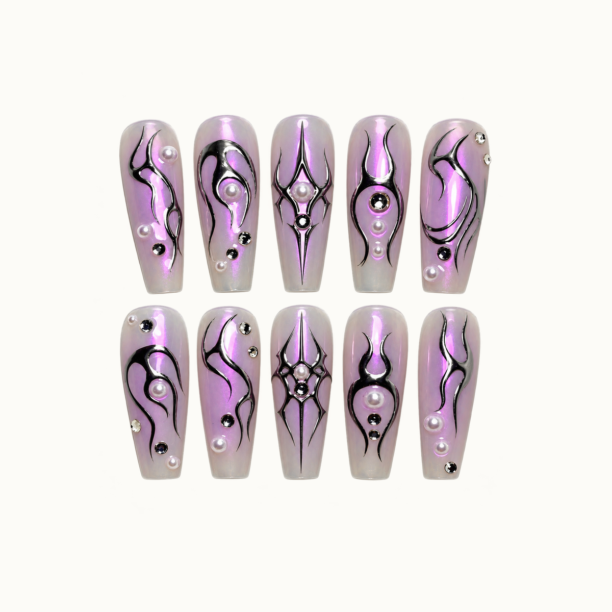 Ten lilac press-on nails arranged in two rows on a light neutral background, with black sigil motifs, pearl-like accents, and reflective gems.