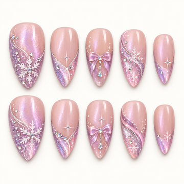 Ten blush pink nails arranged in two rows on a light neutral background, with lavender glitter tips, white snowflakes, pink bows, and gem accents.