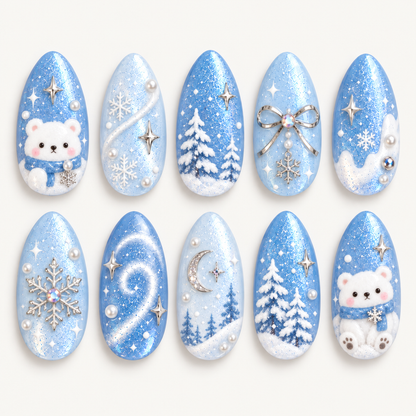 Ten almond-shaped blue winter nails arranged in two rows on a light background, featuring white bears, snowy trees, snowflakes, a silver-tone bow, and a crescent moon.