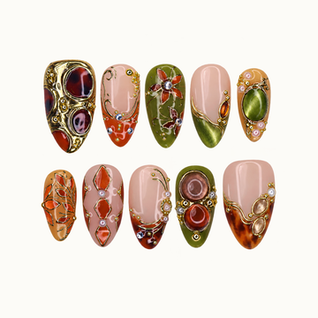 Ten ornate nails arranged in two rows on a pale background, featuring olive, blush, and amber colors with gold-tone botanical and jewel-like details.