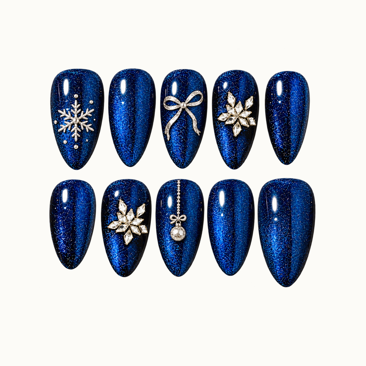 Ten glossy blue shimmer nails arranged in two rows on a light background, with silver-toned snowflake, bow, jewel-cluster, and hanging ornament accents.