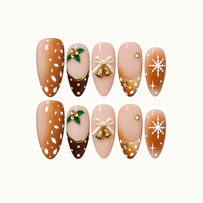 Ten coordinated Christmas press-on nails arranged in two rows on a light background, with caramel and blush bases, holly, gold bells, and white snowflakes.