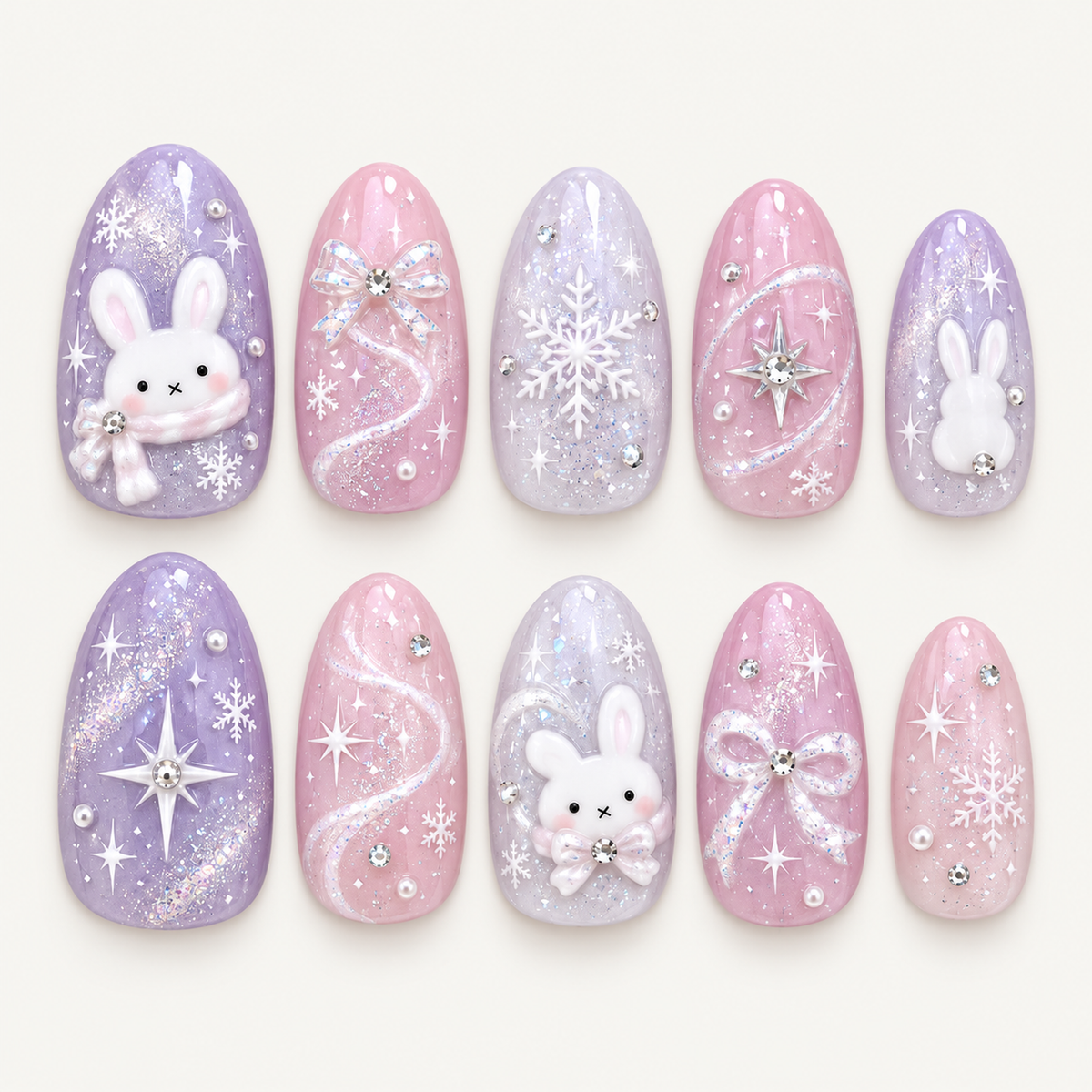 Ten pink, lavender, and pale lilac nails arranged in two rows on a light greige background, with raised bunnies, bows, snowflakes, glitter swirls, and reflective accents.