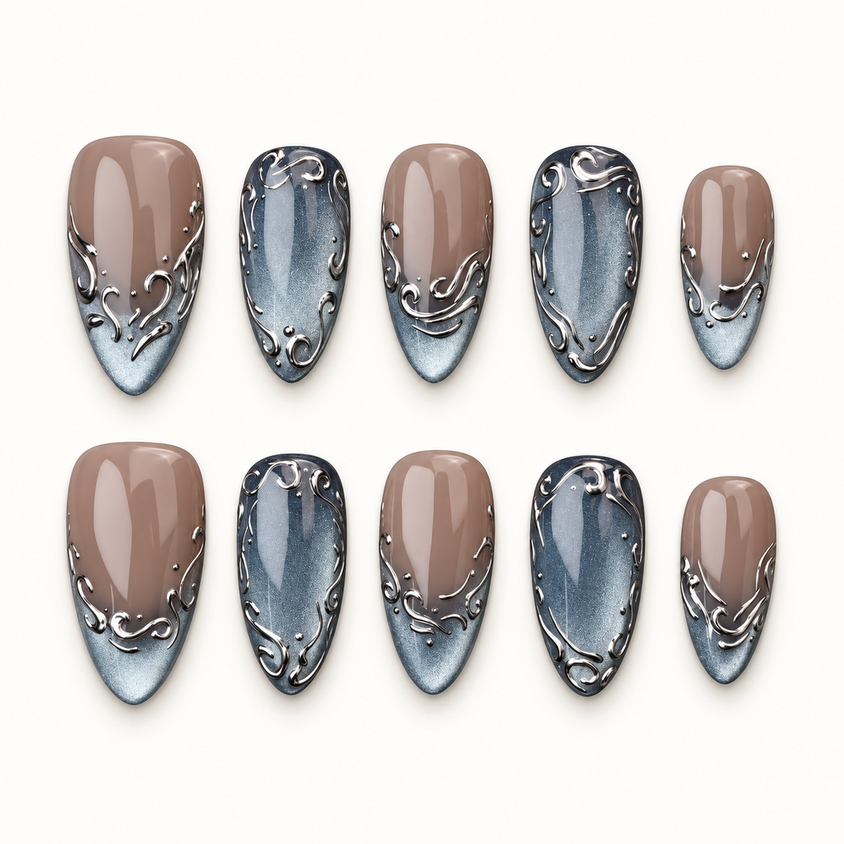 Ten coordinated press-on nails on a light background, alternating greige-to-icy-blue-gray and fuller blue-gray designs with silver-toned scrollwork.