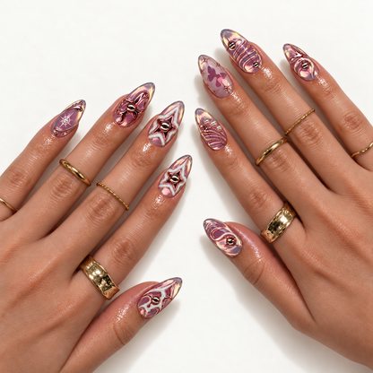 Hand model mockup showing mauve iridescent nails with metallic stars, bows, butterflies, and sweeping linework, styled with gold-toned rings.