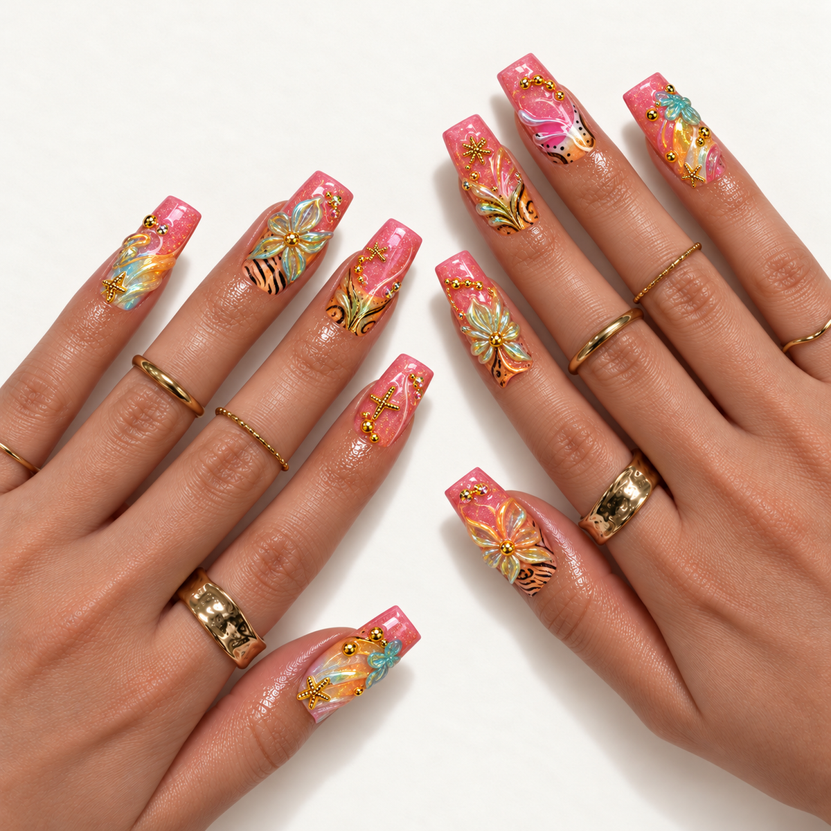 Hand model mockup showing the coral-pink floral nail design with dimensional blooms, black patterns, aqua details, and gold-toned accents, styled with gold-toned rings.