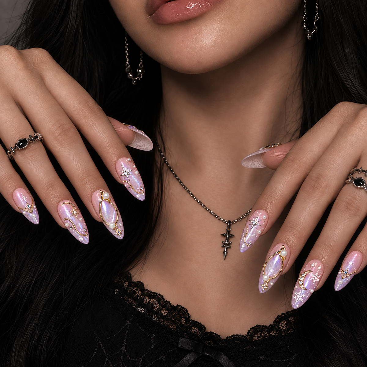 Model mockup showing pink and lilac shimmer nails on both hands near the neckline, with gold-toned celestial details and pearl-like accents.