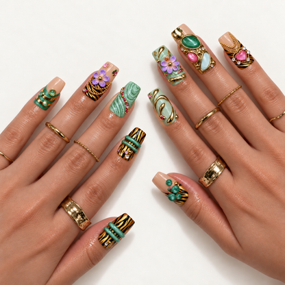 Hand model mockup showing the ornate green, nude, and striped nail design with raised lavender flowers, gold-tone details, and pink accents.