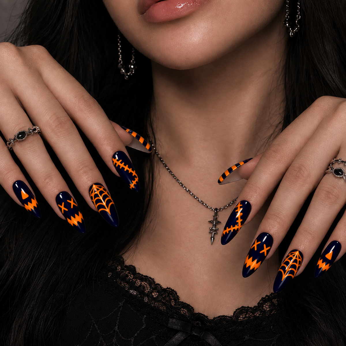 Midnight Web navy and orange graphic press-on nails shown on a hand