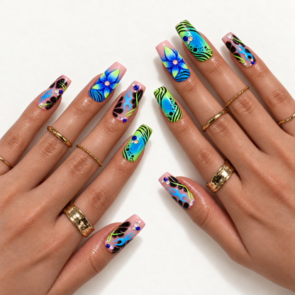 Hand model mockup showing the blue, lime, pink, and black floral and flame nail design worn with gold-toned rings.