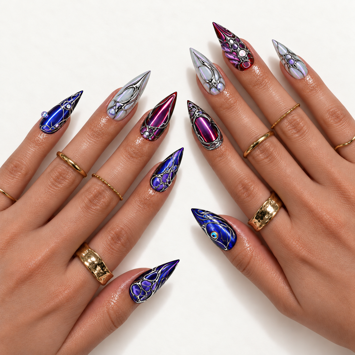 Hand model mockup showing pointed blue, wine-purple, and pearly nails with silver-tone curves and jewel-like accents, styled with gold-tone rings.