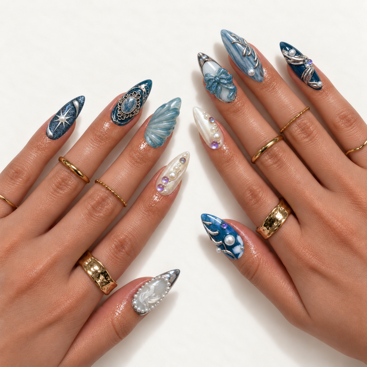 Hand model mockup showing pointed blue and pearl white nails with silver flourishes, pearl-like accents, a swan motif, a blue bow, and shell-like sculpting.