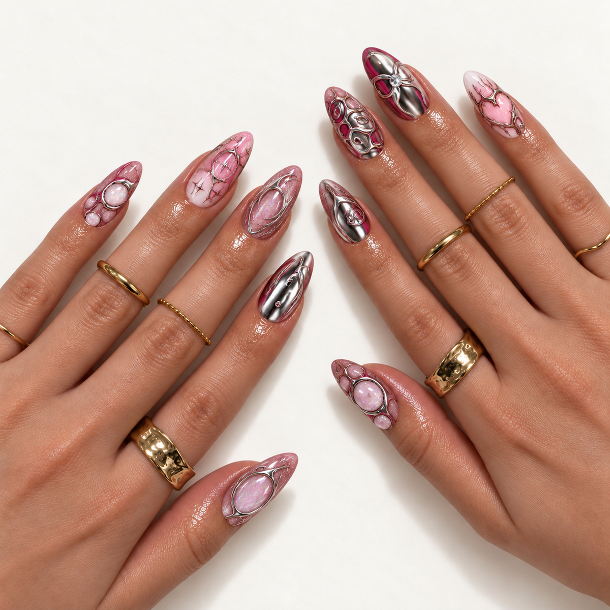 Hand model mockup displaying pink and silver nail art with reflective chrome effects, oval accents, swirls, and a heart, styled with gold-tone rings.